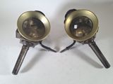 pair of antique brass lamps on tripod legs on a white background