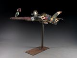sculpture représentant un avion, composée d'engrenages et de roues dentées, posée sur un socle métallique