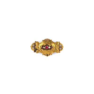 gros plan d'une bague en or avec une pierre rouge au centre