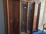 une armoire en bois avec des portes vitrées et une chaise dans une pièce