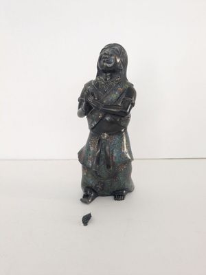 une vieille statue en bronze représentant une femme tenant un bébé dans ses bras