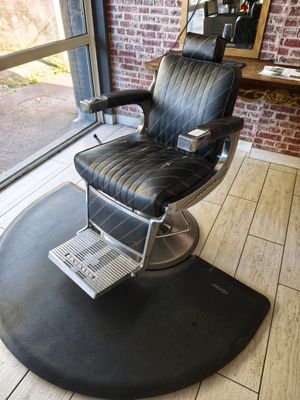 une photo d'un fauteuil de coiffeur devant un mur de briques