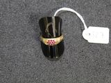 a black ring with a pink stone on it and a price tag