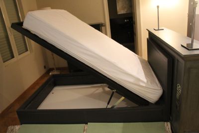 un lit avec un matelas posé dessus, dans une chambre