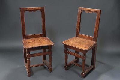 une paire de chaises anciennes en bois avec un miroir sur le dossier