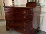 a dresser with a clock on top of it in a room