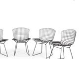 three black wire chairs sitting next to each other on a white surface