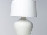 une lampe de table blanche surmontée d'un abat-jour blanc