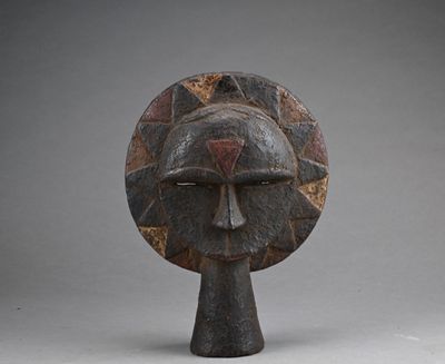 an image of a wooden sculpture of a face on a pedestal