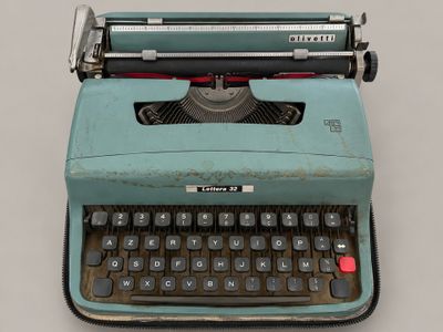 an old typewriter sitting on a table with a gray background