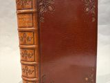 un vieux livre à la couverture brune posé sur une table