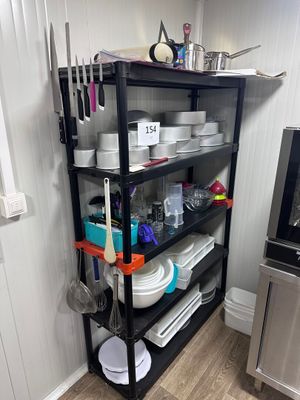 une étagère sur laquelle sont posés de la vaisselle et des casseroles, dans la cuisine