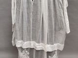 une photo d'un mannequin portant une robe blanche et une cravate noire