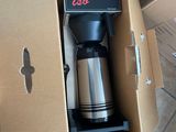 a coffee maker sitting inside of a box on the floor