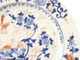 a blue and white plate with flowers and birds on it