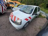 une petite voiture blanche à rayures rouges et blanches garée sur un parking