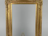 un miroir à cadre doré posé sur un pied, surmonté d'un petit miroir