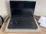 un ordinateur portable posé sur un bureau en bois