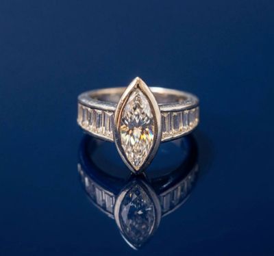 un gros plan d'une bague en diamant posée sur une surface bleue