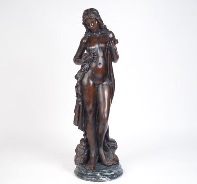une statue antique en bronze représentant une femme tenant un sac