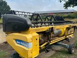 un gros plan d'une moissonneuse-batteuse jaune sur une remorque dans un champ