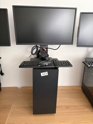Trois écrans d'ordinateur sont posés sur un bureau, à côté d'un clavier et d'une souris