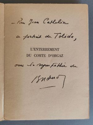 un livre ouvert, sur lequel est posée une note manuscrite, posé sur une table