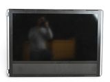 un homme en train de se prendre en photo dans le reflet d'un écran de télévision