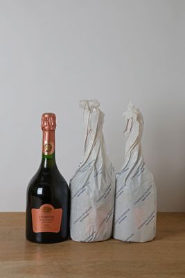 une bouteille de champagne posée à côté de deux sacs sur une table