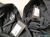two jackets with tags on them sitting next to each other