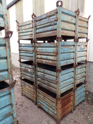 une pile de caisses bleues posées devant un immeuble