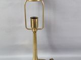 une lampe dorée posée sur une surface blanche