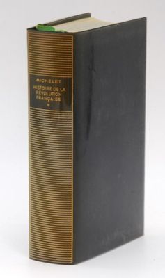a black book sitting on top of a table next to a white wall