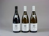 trois bouteilles de vin posées l'une à côté de l'autre sur une table