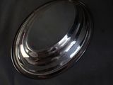 a silver plate with a mirror on it on a black cloth