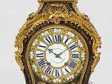 une horloge en or avec des chiffres romains bleus et blancs