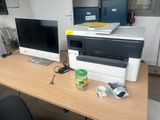 un ordinateur et une imprimante posés sur un bureau dans un bureau