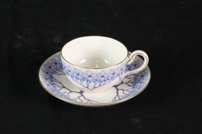 une petite tasse et une soucoupe posées sur une table noire