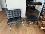 une chaise noire et un pouf noir dans une pièce