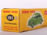 an old green toy car in a box on a white surface