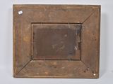 an old wooden picture frame on a white wall with a tag on it