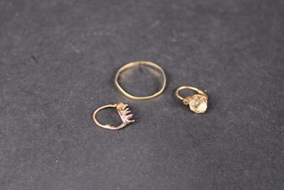 deux bagues en or et une bague en or sur un fond noir