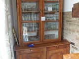 un meuble en bois avec des portes en verre dans le coin d'une pièce