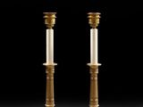 a pair of brass candlesticks with candles on each of them