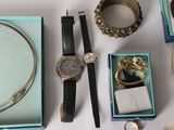 a table with a watch, bracelets, and other items on it