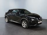 the black nissan juke suv is parked in a showroom