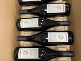 six bottles of wine are in a cardboard box on a table