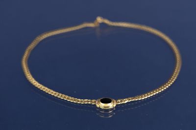 un bracelet en chaîne d'or orné d'une perle en pierre noire