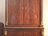 a wooden cabinet and a suitcase in a room