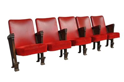 une rangée de chaises rouges aux pieds noirs sur fond blanc